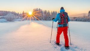 Snowshoe walker running in powder snow with beautiful sunrise light. Outdoor winter activity and healthy lifestyle_shutterstock_568607152.jpg