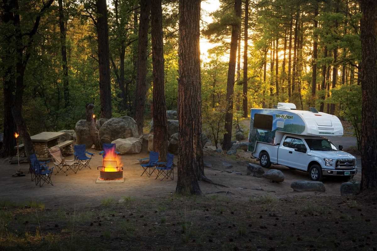 Camper im Wald mit Lagerfeuer
