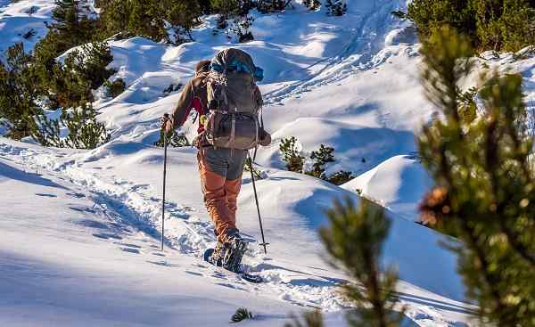 Man walking with snowshoes in mountains shutterstock 399839725